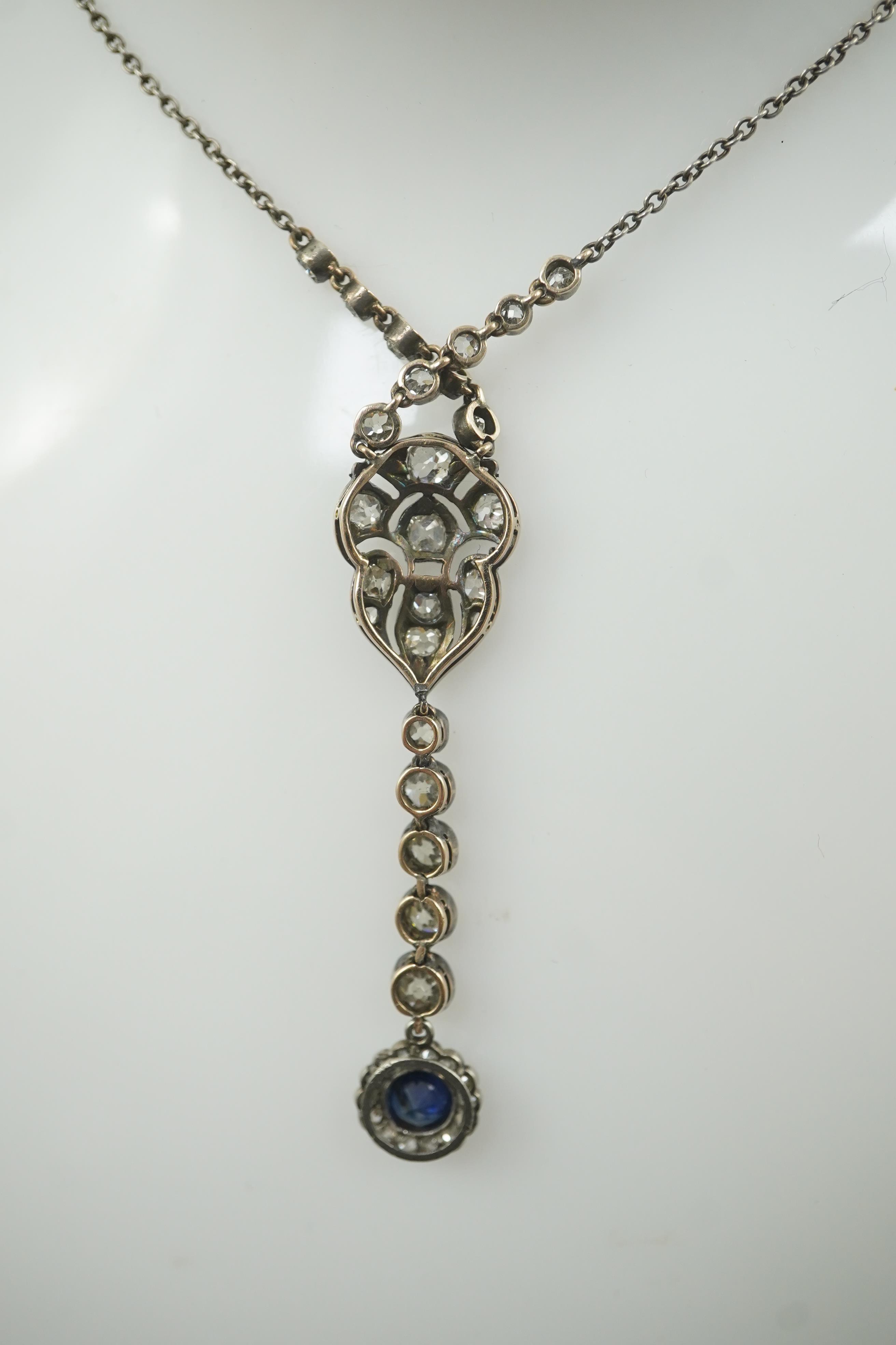 A Belle Epoque gold and silver, millegrain set sapphire and diamond cluster set drop pendant necklace